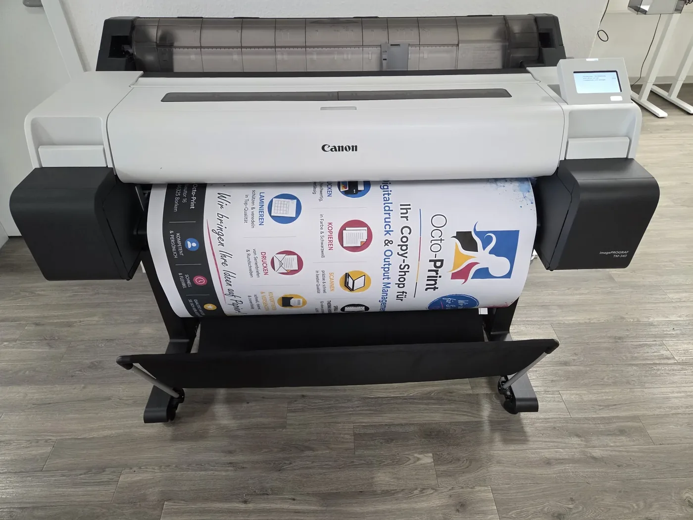 Der Großformatdrucker druckt ein Plakat mit den Leistungen von Octo-Print